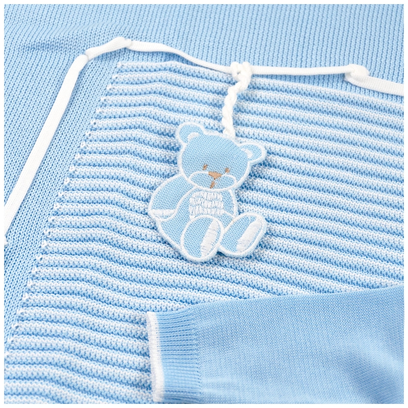 Detail of knitted newborn first outing layette set with teddy embroidery