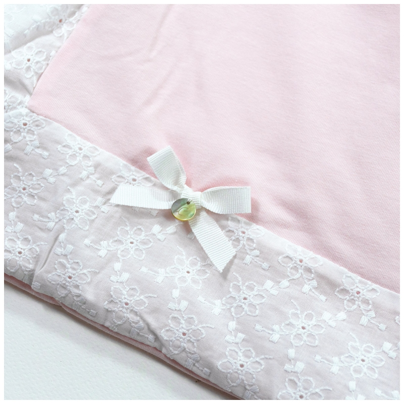 Detail of cotton jersey crib blanket with embroidered trim