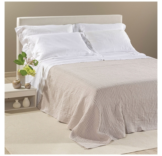 Copriletto in cotone matrimoniale Paraggi Caleffi beige su letto con cuscini bianchi