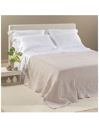 Copriletto in cotone matrimoniale Paraggi Caleffi beige su letto con cuscini bianchi