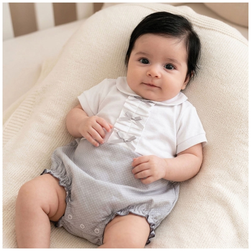 Pagliaccetto neonata in cotone piquet pois con dettagli plissettati