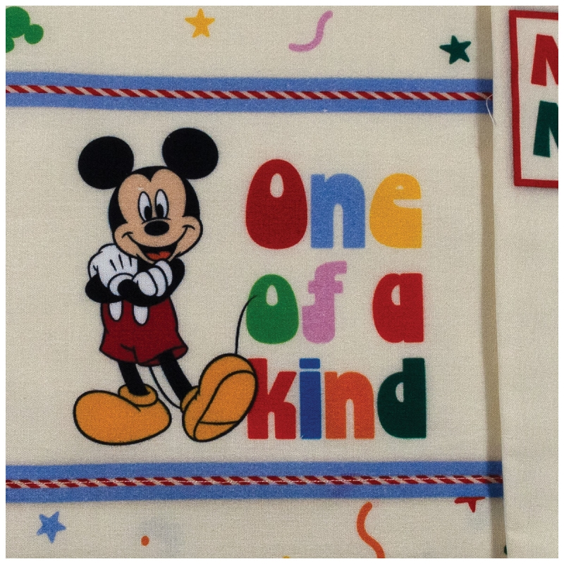 Close-up of Topolino print on creamy natural cotton fabric for newborn bedding