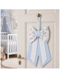 Home door decorated with pink baby birth bow in nursery style setting