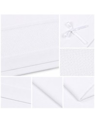 Close-up of piqué cotton trim and embroidery aida insert on newborn cot bedding
