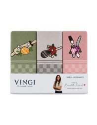 Embroidered kitchen towels with rolling pin, whisk and floral cutlery photographed in a warm and bright kitchen setting.