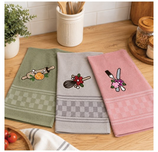 Tris di strofinacci cucina in spugna con ricami utensili da cucina nei colori verde salvia, beige e rosa su tavolo in legno.
