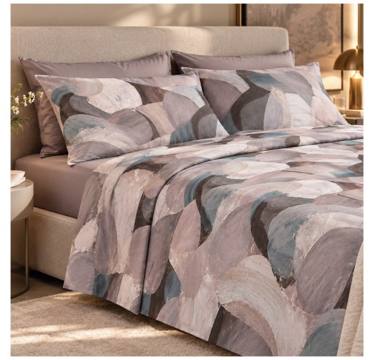 Double bed dressed with a printed summer flat sheet and plain fitted sheet